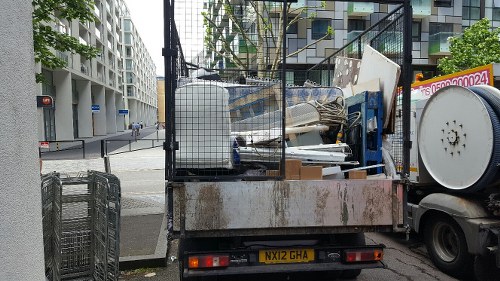 Loading an enclosed skip with household waste